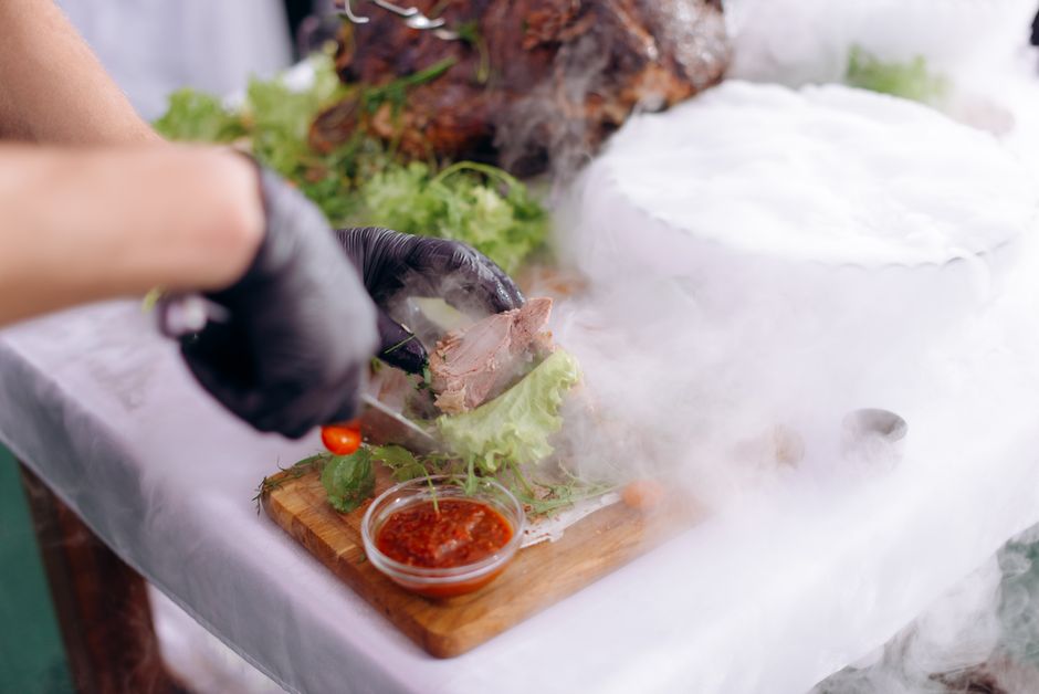 Chef priprema gurmansko jelo s dimom i ukrasnim sastojcima na daski za rezanje
